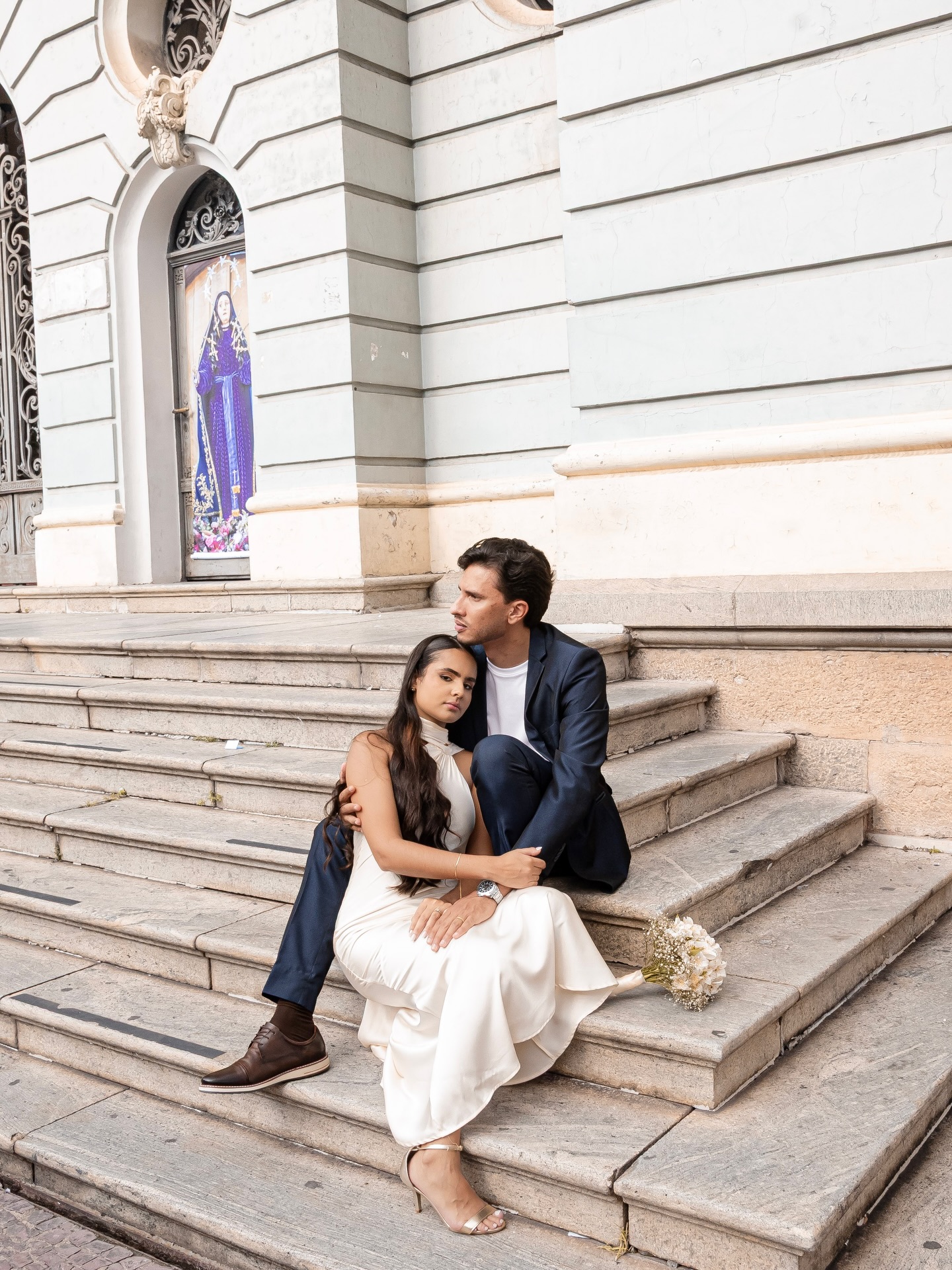 Casal sentado na escadaria da igreja após o casamento civil