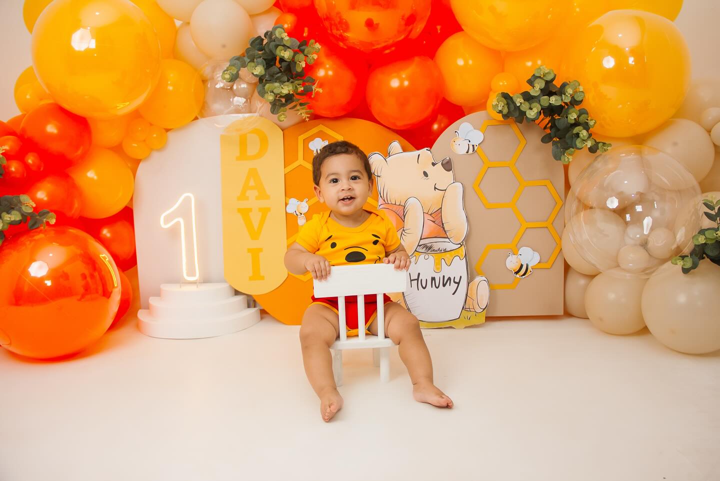 Bebê em ensaio smash the cake de 1 ano com tema Ursinho Pooh